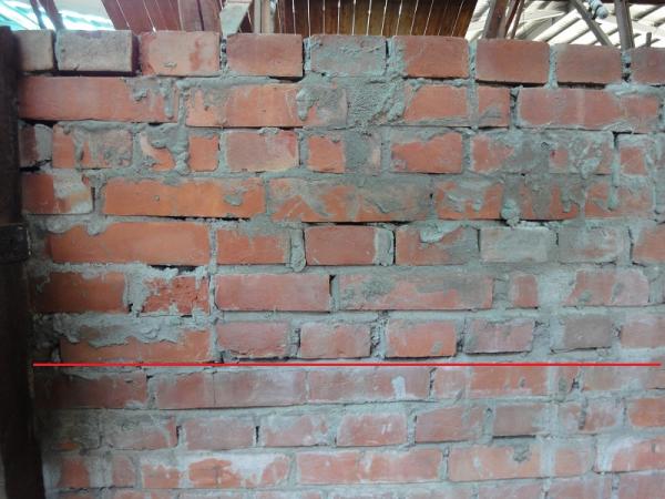 1021004新砌磚牆屋面板拆卸後，於南側磚牆發現新舊磚牆痕跡。如圖，紅線上方均為後期新砌磚牆。